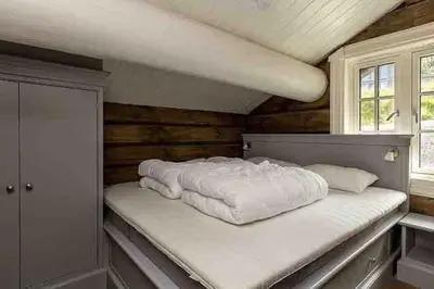 a large white bed in a room with a window at Stor og eksklusiv tømmerhytte Hemsedal in Grøndalen