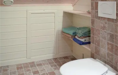 a bathroom with a toilet and some towels at Cozy Home In Norheimsund With Sauna in Norheimsund