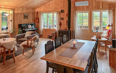 a living room with a wooden table and chairs at 4 Bedroom Cozy Home In Straumgjerde in Brunstad