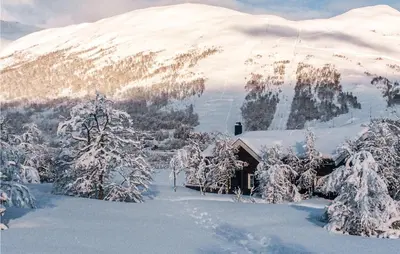 a house covered in snow in front of a mountain at 4 Bedroom Cozy Home In Straumgjerde in Brunstad