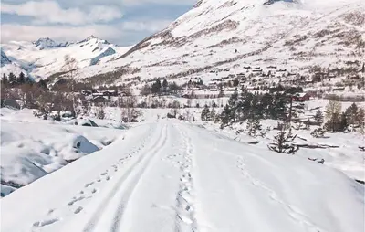 a road covered in snow with a mountain in the background at 4 Bedroom Cozy Home In Straumgjerde in Brunstad