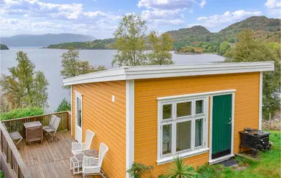 a small house on a deck with a view of a lake at 1 Bedroom Nice Home In Skånevik in Skånevik