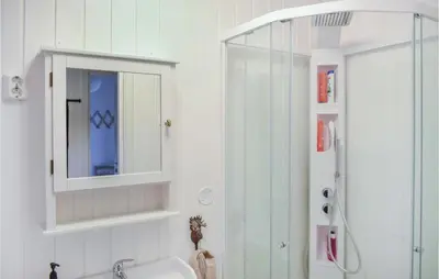 a bathroom with a sink and a mirror and a shower at 1 Bedroom Nice Home In Skånevik in Skånevik