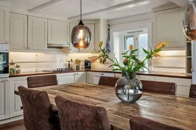a kitchen with a wooden table with a vase on it at Stamp and sauna! Small farm with fantastic view! in Favang