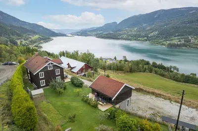 an aerial view of a house next to a lake at Stamp and sauna! Small farm with fantastic view! in Favang