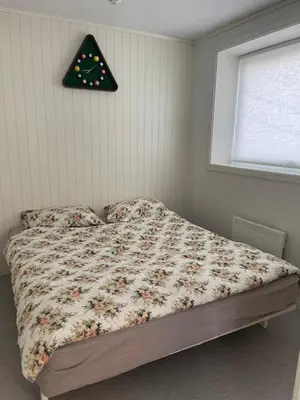 a bedroom with a bed and a clock on the wall at Lovely apartment with parking in the heart of city in Lillehammer