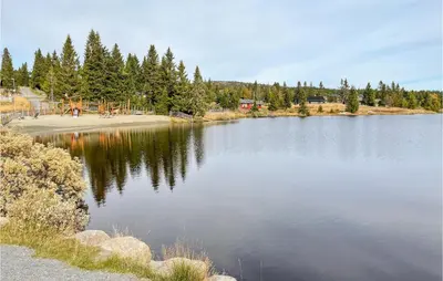 a large lake with a playground in the middle of it at Stunning Home In Sjusjøen With Sauna in Sjusjøen