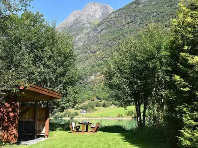 a picnic table next to a lake with a mountain at 4 person holiday home in Oldedalen-By Traum in Briksdalsbre