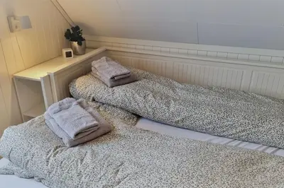 two beds in a room with towels on them at The Fjord House in Snofugl