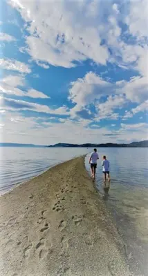 a couple of people walking on the beach at The Fjord House in Snofugl