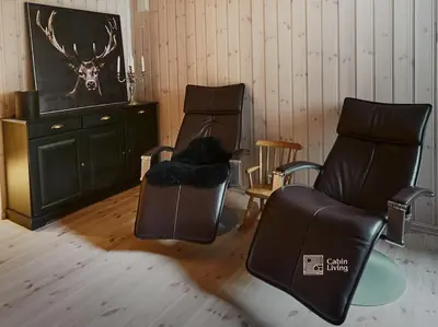 a living room with two chairs and a tv at Large cabin at Nesfjellet with lovely view, inddor Jacuzzi & sauna in Nes i Ådal
