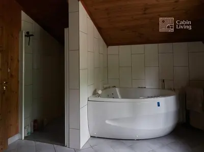 a white tub in a bathroom with a wooden ceiling at Large cabin at Nesfjellet with lovely view, inddor Jacuzzi & sauna in Nes i Ådal