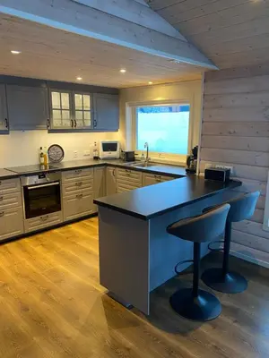 a kitchen with a counter and a stool in it at Fjelltun Lodge in Sogndal