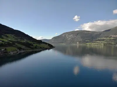 a large body of water with mountains in the background at Moderne panoramaleilighet 3-roms i Olden in Olden
