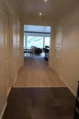 a hallway with a dining room and a dining table at Moderne panoramaleilighet 3-roms i Olden in Olden