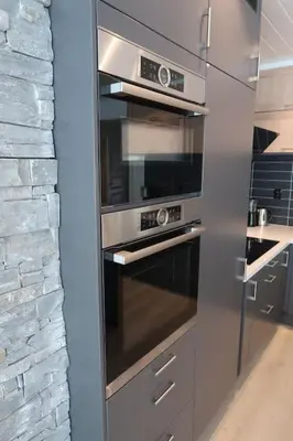 a stainless steel oven in a kitchen with a brick wall at Moderne panoramaleilighet 3-roms i Olden in Olden