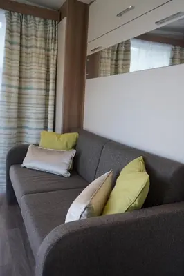 a couch with three pillows on it in a room at Koie Smart in Stranda