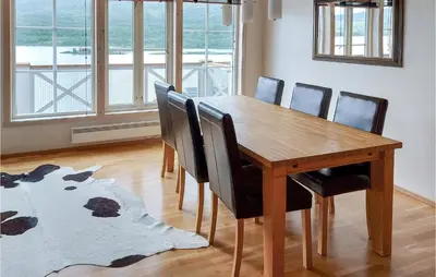 a wooden dining room table with chairs and a rug at Awesome Apartment In Tyinkrysset in Tyinkrysset