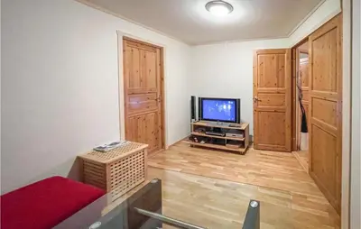 a living room with a television and a red couch at Awesome Apartment In Tyinkrysset in Tyinkrysset