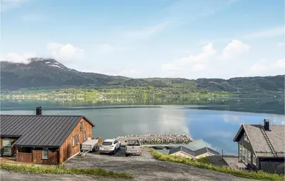 a view of a lake with cars parked next to a house at Stunning Home In Gjemnes With Wifi in Stokke