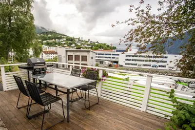 a patio with a table and chairs on a balcony at Koie Standard in Stranda