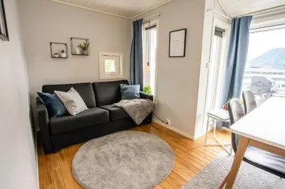 a living room with a black couch and a window at Koie Standard in Stranda