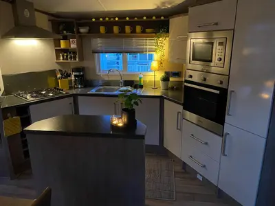 a kitchen with white appliances and a black counter top at Koie Holiday Home 3 in Stranda