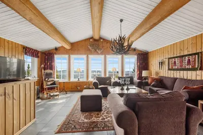a living room with couches and a tv and windows at Trysilfjellet in Trysil