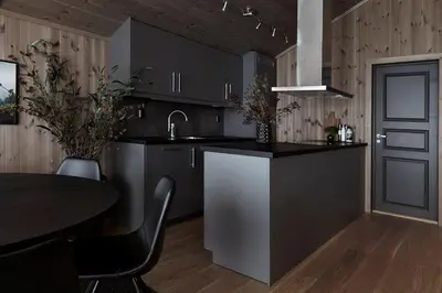 a kitchen with black cabinets and a table and a sink at Trysilfjellet in Trysil
