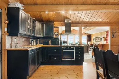 a kitchen with black cabinets and a wooden ceiling at Trysilfjellet in Trysil
