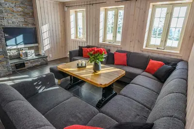 a living room with couches and a table with flowers at Trysilfjellet in Trysil