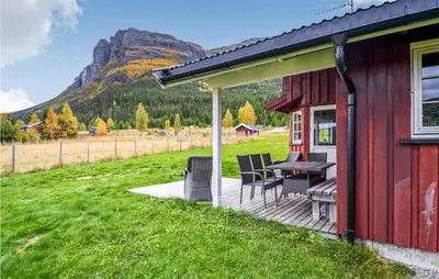a red house with a table and chairs on a deck at Gorgeous Home In Hemsedal With Sauna in Hemsedal