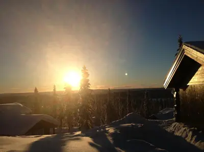 a winter sunset with the sun in the background at Stor familiehytte på Småsætra, Sjusjøen in Sjusjøen