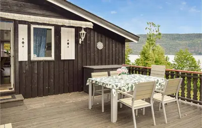 a table and chairs on the deck of a house at 4 Bedroom Nice Home In Vikersund in Vikersund