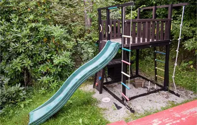 a playground with a slide in the grass at 4 Bedroom Nice Home In Vikersund in Vikersund