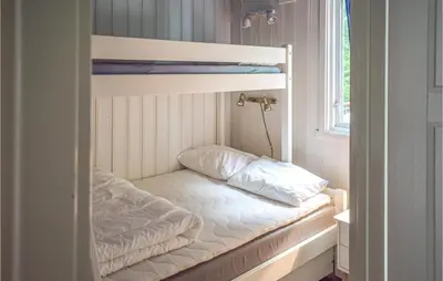 a bunk bed with two pillows on it next to a window at 4 Bedroom Nice Home In Vikersund in Vikersund