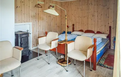 a bedroom with a bed with a table and chairs at 4 Bedroom Nice Home In Vikersund in Vikersund