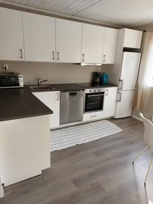 a kitchen with white cabinets and stainless steel appliances at peaceful place in Hønefoss