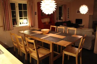 a dining table and chairs in a living room at Gålå Fjellhytte - cabin with sauna and whirlpool tub in Sør-Fron
