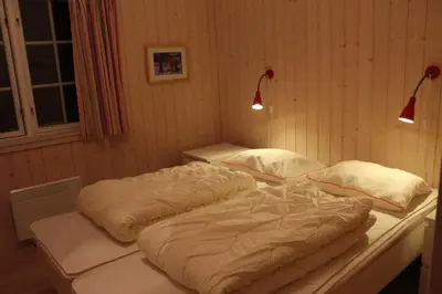 two large beds in a room with two lamps at Gålå Fjellhytte - cabin with sauna and whirlpool tub in Sør-Fron