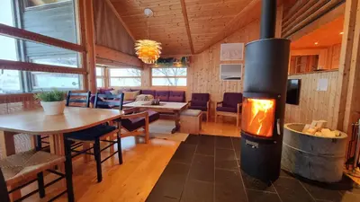 a restaurant with a fireplace in the middle of a room at Svarthamar - cabin with amazing view in Ål