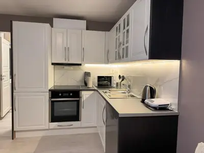 a white kitchen with white cabinets and a sink at Chausseen Apartments in Krogsti