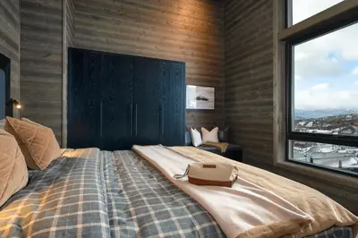 a bedroom with a bed with a purse on it at Riddertunets top notch in Beitostøl