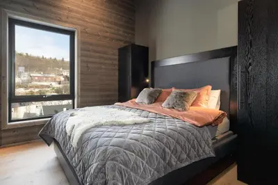 a bedroom with a large bed with a large window at Riddertunets top notch in Beitostøl