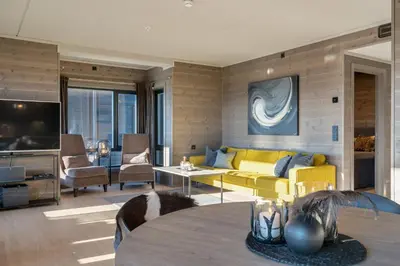 a living room with a yellow couch and a table at Riddertunet deluxe in Beitostøl