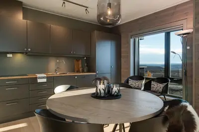 a kitchen with a table and some chairs and a window at Riddertunet deluxe in Beitostøl