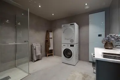 a bathroom with a washing machine and a sink at Riddertunet deluxe in Beitostøl