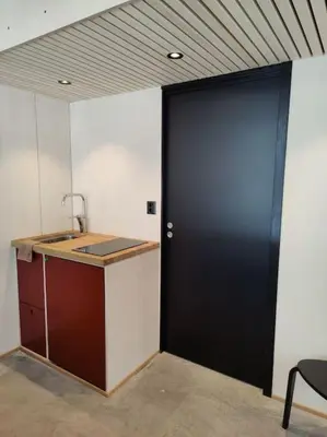 a black door in a room with a counter at Minihuset ved skogen in Isfjorden
