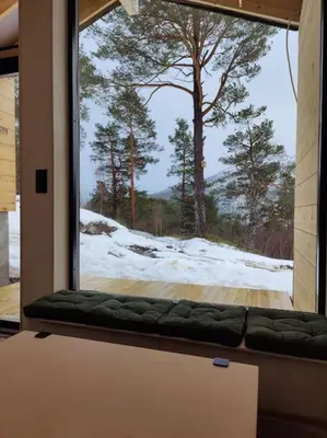 a window with a couch in a room with a view at Minihuset ved skogen in Isfjorden