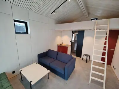 a living room with a couch and a bunk bed at Minihuset ved skogen in Isfjorden